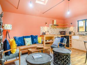 een woonkamer met oranje muren en een bank en stoelen bij Okovango - Uk44824 in Holton