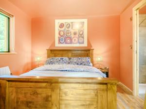 een slaapkamer met een houten bed en een schilderij aan de muur bij Okovango - Uk44824 in Holton