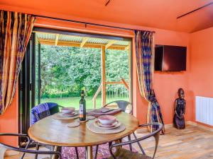 een eetkamer met een tafel en een groot raam bij Okovango - Uk44824 in Holton