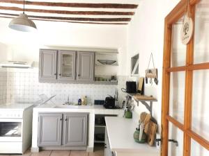eine Küche mit weißen Schränken und einer weißen Arbeitsplatte in der Unterkunft The Olive Press - Mon Lodge en Provence in Caromb