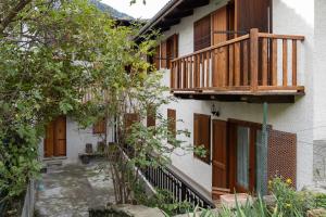 a building with a wooden balcony and a staircase at Maison Bertines II in Casteldelfino