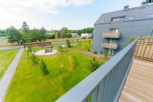 uitzicht op een tuin vanaf het balkon van een gebouw bij Apartament SAIL SurfingBird Dźwirzyno in Dźwirzyno