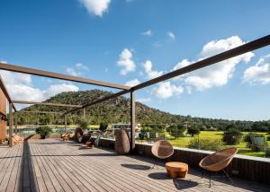 a deck with chairs and a view of a mountain at Kimpton Aysla Mallorca by IHG in Santa Ponsa