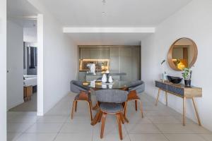 a dining room with a table and a mirror at Premium Albert Park Grand Prix Apartment by Ready Set Host in Melbourne