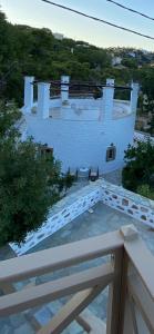 einen Balkon mit Blick auf ein weißes Gebäude in der Unterkunft Cybele guesthouse in Chrousa