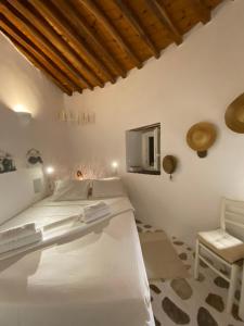 1 Schlafzimmer mit einem weißen Bett und einem TV in der Unterkunft Cybele guesthouse in Chrousa