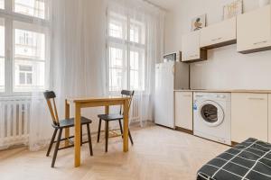 プラハにあるVita Nejedleho apartmentsのキッチン(テーブル、椅子、洗濯機付)