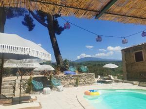 eine Terrasse mit einem Pool, Stühlen und einem Sonnenschirm in der Unterkunft The Olive Press - Mon Lodge en Provence in Caromb