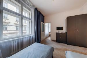 プラハにあるVita Nejedleho apartmentsのベッドルーム1室(ベッド1台、窓、ドレッサー付)