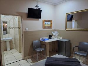 a room with a bathroom with a sink and a shower at Sleep 'n Go Guesthouse in Mokopane