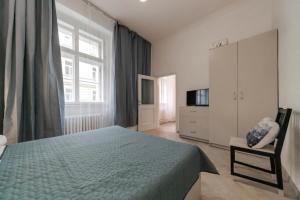 プラハにあるVita Nejedleho apartmentsのベッドルーム(ベッド1台、テレビ、椅子付)