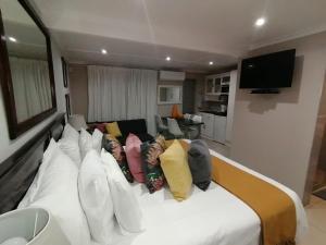 ein Wohnzimmer mit einer weißen Couch mit bunten Kissen in der Unterkunft Tri-Angle B&B and Guesthouse in Adelaide