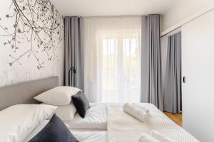 a white bedroom with a bed and a window at Apartament BLUE BIRD SurfingBird Dźwirzyno in Dźwirzyno