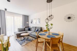 a living room with a table and a couch at Apartament BLUE BIRD SurfingBird Dźwirzyno in Dźwirzyno