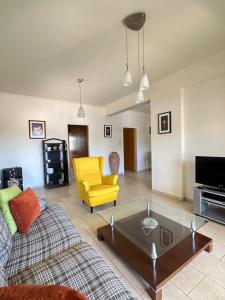 a living room with a couch and a yellow chair at Relaxing Gateway in Limassol in Episkopi Limassol