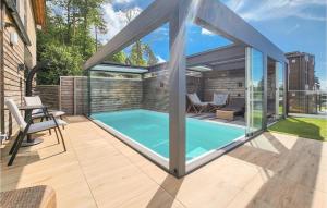uma piscina numa casa com uma extensão de vidro em Awesome Home In Brevik With Indoor Swimming Pool, Private Swimming Pool And 5 Bedrooms em Brevik