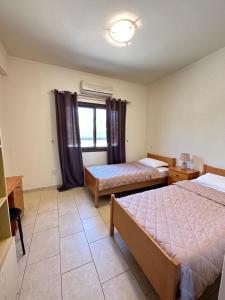 a hotel room with two beds and a window at Relaxing Gateway in Limassol in Episkopi Limassol