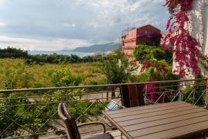 - un balcon avec une table en bois et des fleurs dans l'établissement Mannou House, à Paralia Vrachou