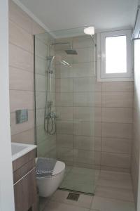 La salle de bains est pourvue d'une douche, de toilettes et d'une fenêtre. dans l'établissement Mannou House, à Paralia Vrachou