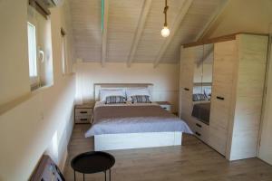 sypialnia z dużym łóżkiem i drewnianym sufitem w obiekcie Mannou House w mieście Paralia Vrachou