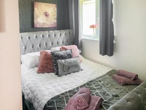 Un dormitorio con una cama con almohadas. en Sunny Prestatyn Apartment en Prestatyn