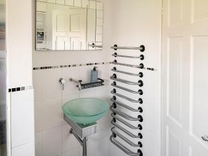baño con lavabo verde y espejo en Sunny Prestatyn Apartment en Prestatyn