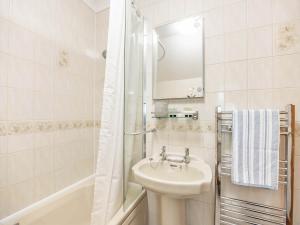 biała łazienka z umywalką i prysznicem w obiekcie The Granary w mieście Tetford