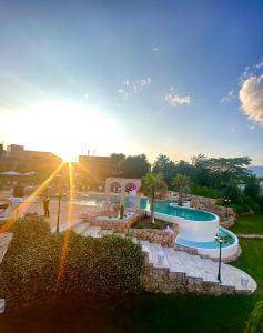a view of a swimming pool with the sun setting at Hotel Colaiaco in Anagni