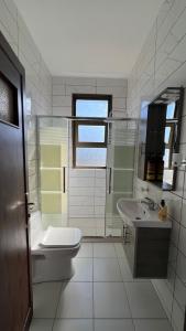 a white bathroom with a sink and a toilet at Al-jabal castle Hotel - Ajloun in Ajloun