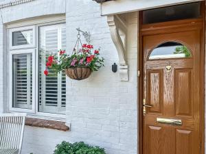 a front door of a house with a basket of flowers at Selsmore Cottages in South Hayling
