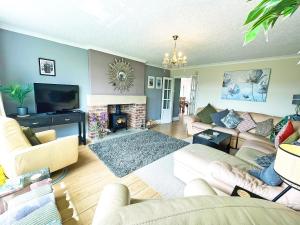 a living room with a couch and a fireplace at Keepsake View in Two Dales