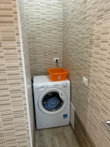 a washing machine with an orange basket on top of it at Gio' locazione turistica in Conversano