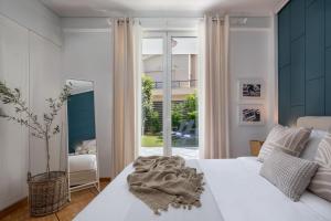 a bedroom with a white bed and a large window at The Southern Mansion Athens in Athens