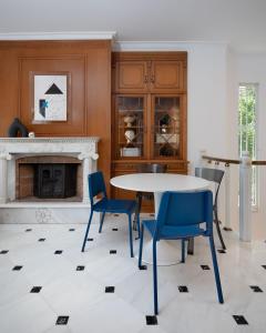 een eetkamer met een tafel en stoelen en een open haard bij The Southern Mansion Athens in Athene