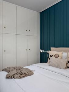 a bedroom with a white bed with a green wall at The Southern Mansion Athens in Athens