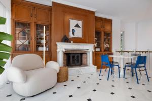 a living room with a fireplace and a table and chairs at The Southern Mansion Athens in Athens