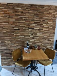 un tavolo in legno con due sedie di fronte a un muro di mattoni di zomerhuis in Wijk aan Zee! 2 pers a Wijk aan Zee