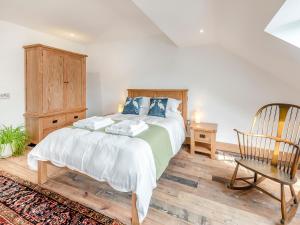 a bedroom with a large bed and a chair at Herons Den - Uk44529 in Horncastle