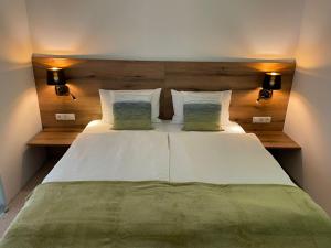 a bedroom with a large white bed with two pillows at River Lilly Apartment in Obertraun