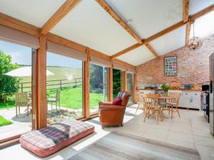 an open kitchen and dining room with large windows at Parish Land Barn in Spaxton