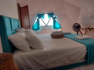 1 dormitorio con 1 cama grande y ventana en Aqua Breeze Glamping, en San Bernardo del Viento