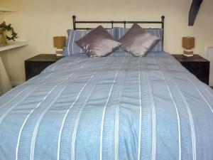 a blue bed with two pillows on it at Seagull Cottage in Whitby