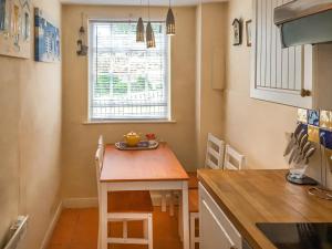a small kitchen with a table and a window at Seagull Cottage in Whitby