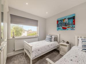 a bedroom with two beds and a window at Castle View House in Amble