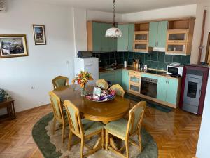 a kitchen with a wooden table with chairs and a dining room at ASKonak Apartman Novi Pazar Centar in Novi Pazar