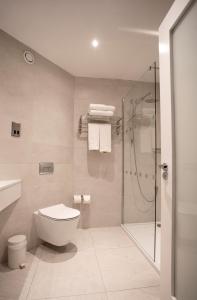 a bathroom with a toilet and a glass shower at Grand Hotel in Malahide