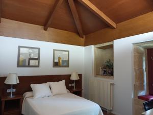 1 dormitorio con cama y techo de madera en Casa das Capelas, en Villamarín