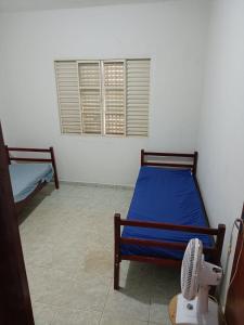a room with two beds and a fan in it at Chacara Tropicalia in Passos