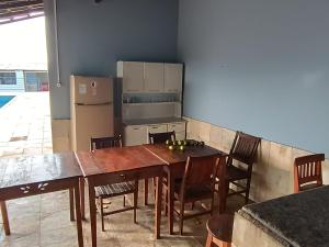 uma cozinha com uma mesa e cadeiras e um frigorífico em Chacara Tropicalia em Passos