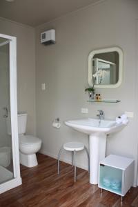 a white bathroom with a sink and a toilet at The Lake Motel in Taupo